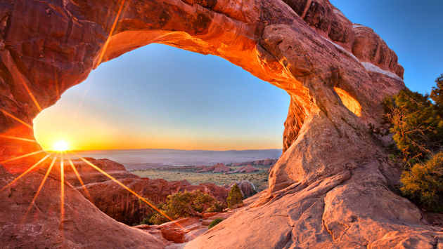 Sunrise at Partition Arch, in Arches National Park. (photo via tonda / iStock / Getty Images Plus)