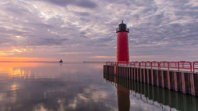 Red lighthouse on Lake Michigan at sunrise in Milwaukee, WI (photo via AMCImages / iStock / Getty Images Plus)