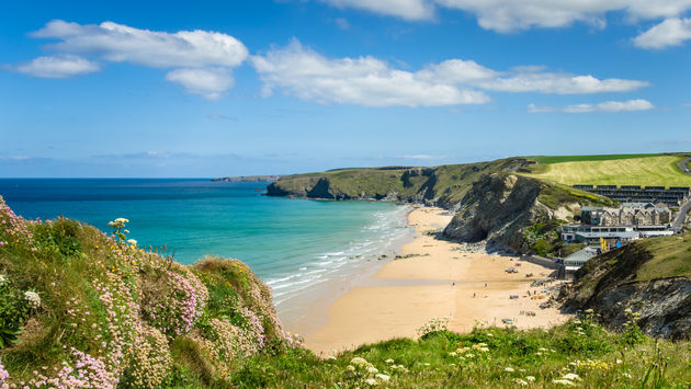 Photo of a Stretch of Coast in Cornwall with a Sandy Beach at the foot of high cliffs. (Photo via AlbertPego / iStock / Getty Images Plus)