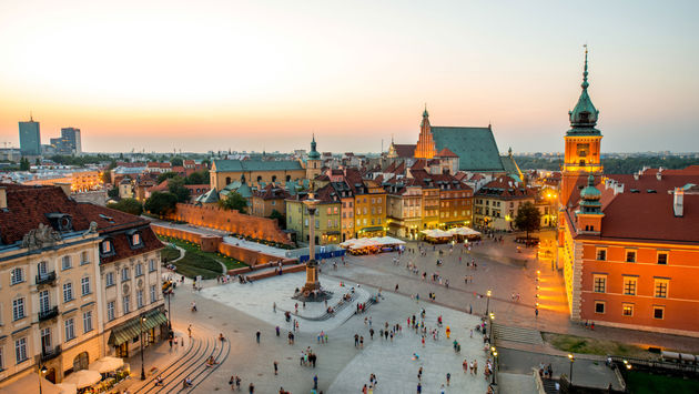 Top view of Royal castle and old town crowded with people in Warsaw on the evening (photo via RossHelen / iStock / Getty Images Plus)