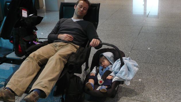 Infant and father napping at the airport