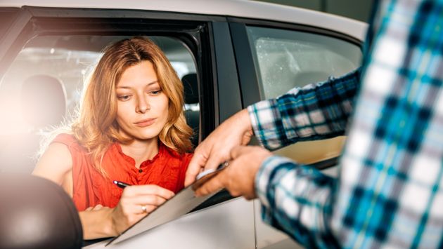 Woman signing car rental agreement