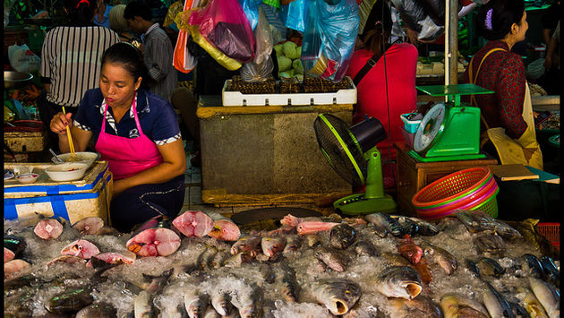 A fishmonger eats at her food stall in the Phnom Penh Central Market.
