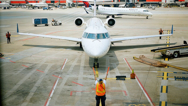 Airport worker directs a plane