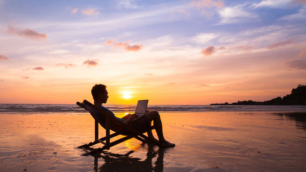 bleisure, digital nomad, remote working, laptop, beach, sunset