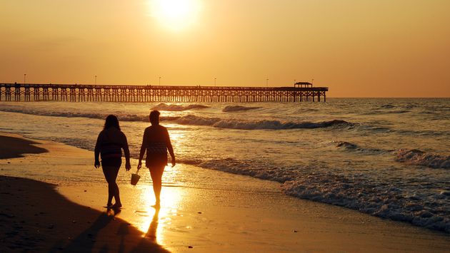 Two women walk along the shore in Myrtle Beach, South Carolina