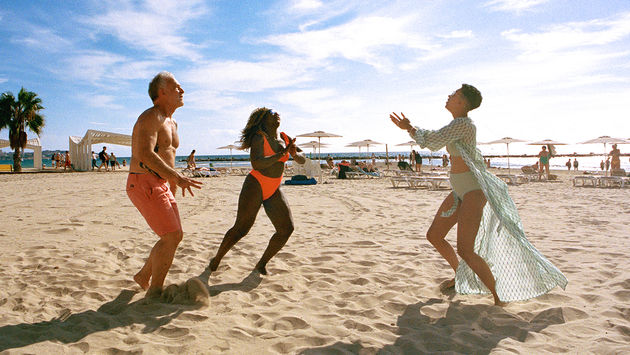 Influencer di viaggio e attivisti LGBTQ+, Aisha e Lexie, si godono una partita di pallavolo sulla spiaggia.