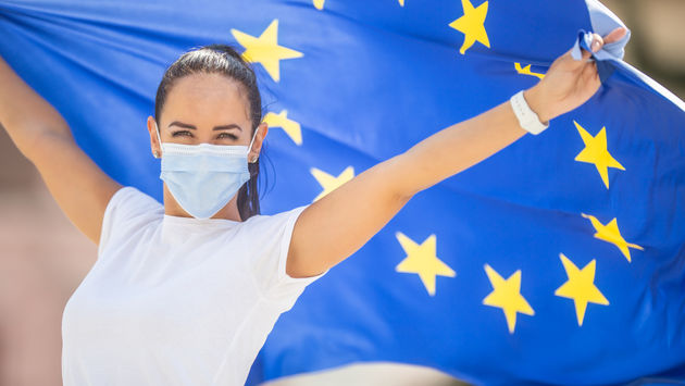 Woman wearing a face mask and flying an E.U. flag.