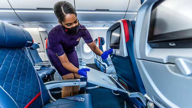 Delta flight attendant cleaning on board.