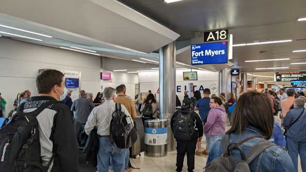 Airport crowd gathers at gate to board flight