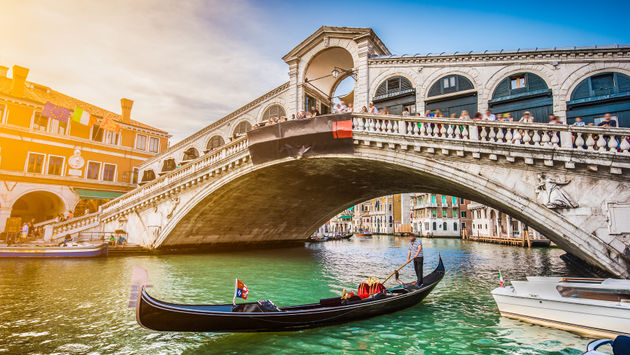 Gondola on Canal Grande with Rialto Bridge at sunset, Venice, Italy