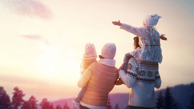 Happy family at sunset in winter (Photo via Choreograph / iStock / Getty Images Plus)