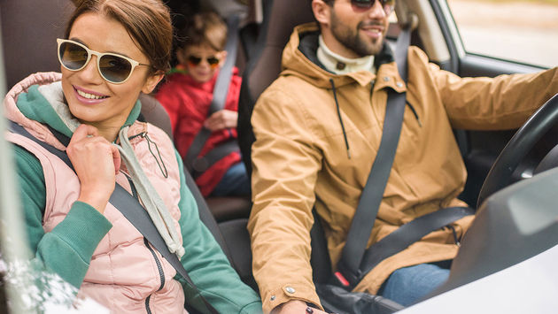 Happy family travelling by car (Photo via LightFieldStudios / iStock / Getty Images Plus)