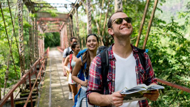 Group of travel companions crossing a forest bridge in Colombia.