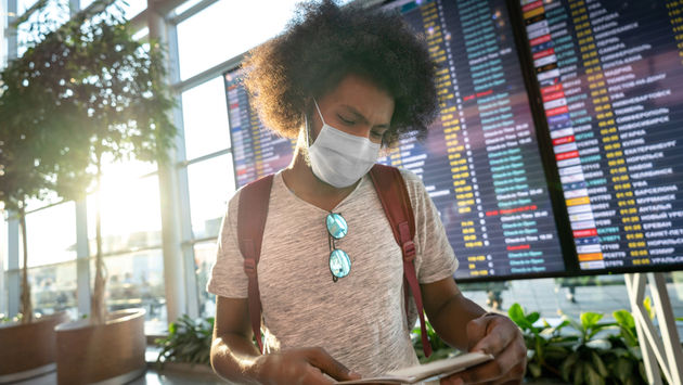 Male traveler wearing a facemask at the airport.