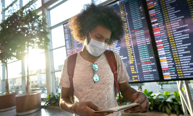 Male traveler wearing a facemask at the airport.
