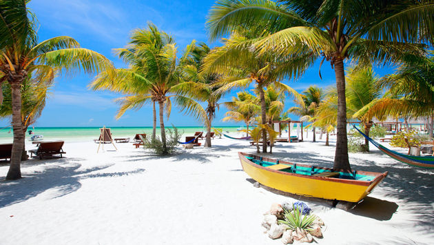 A beach with hammocks and palm trees in Isla Holbox, Mexico