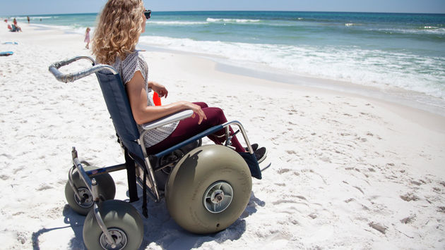 A woman in a beach wheelchair on a beach in South Walton, Florida.