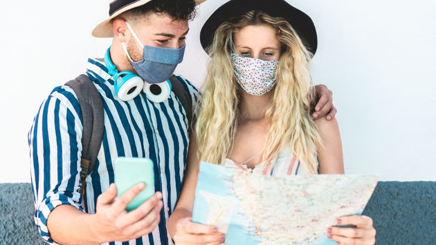 Young couple examining a map while vacationing amid COVID-19.