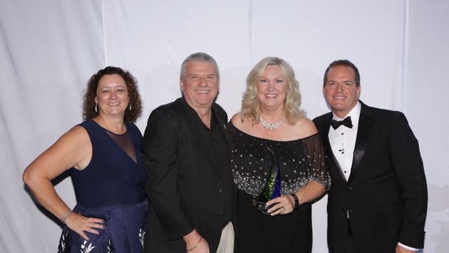 PHOTO: Debbie Fiorino, left, and Drew Daly, right, honor 2018 Dream Vacations Franchisee of the Year Susan Pretkus-Combs; also pictured is 2017 honoree Mike Ziegenbalg. (Photo by www.TheLXA.com courtesy of Dream Vacations/CruiseOne)