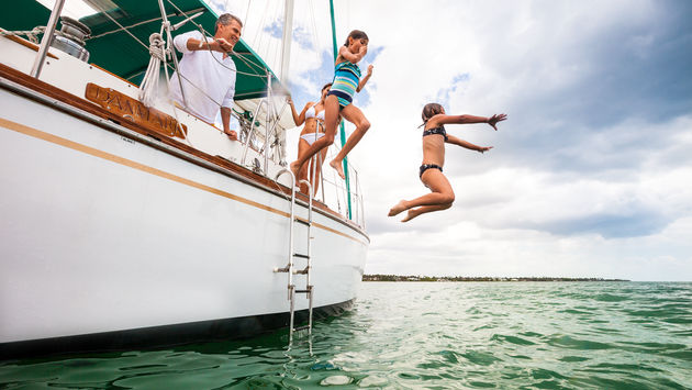 Kids jumping off a sailboat