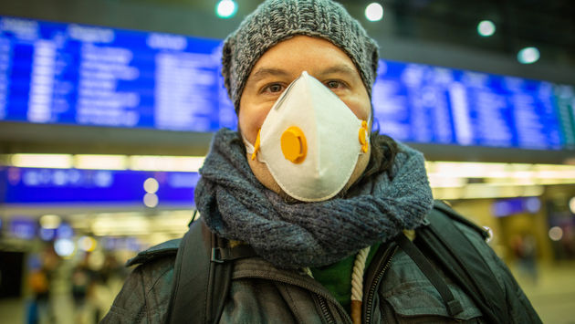 Man wearing a mask at a train station