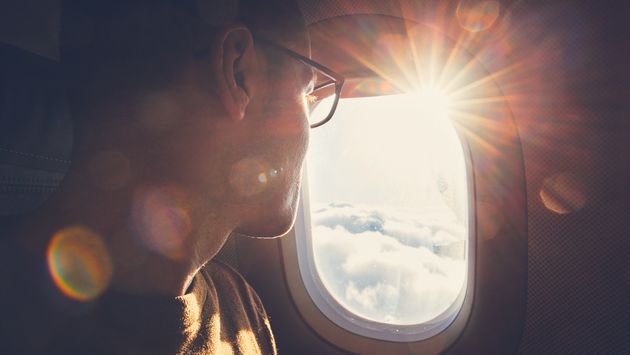 Passenger watches the sunrise through an airplane window