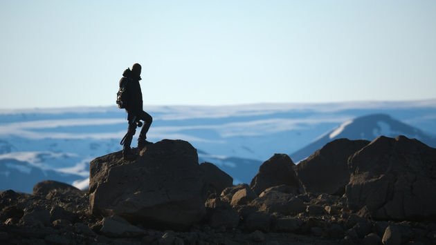 A traveler standing on a cliff in the Icelandic Highlands