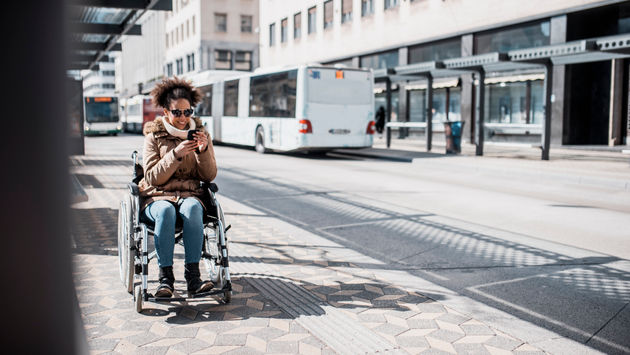 Woman in a wheelchair waiting on the bus