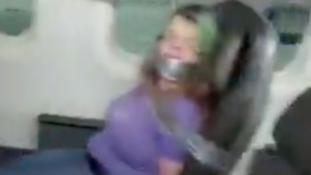 A still from social media footage of an airplane passenger duct-taped to her seat after assaulting crew members.