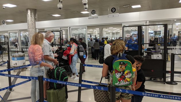 Travelers wait in the security line at the airport