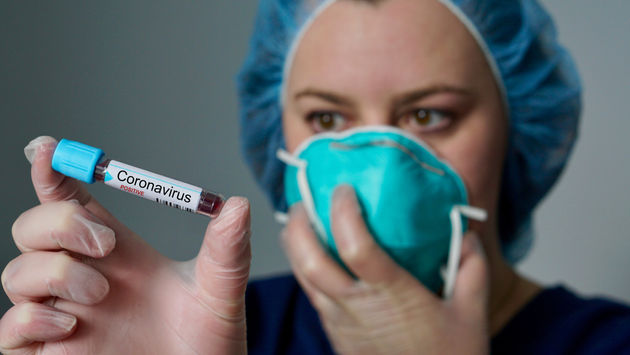 Nurse holding a coronavirus-positive test tube.
