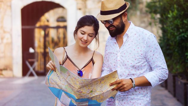 Feliz pareja de turistas sosteniendo un mapa