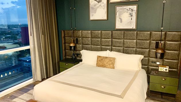 Hotel room with leather accents white sheet bed