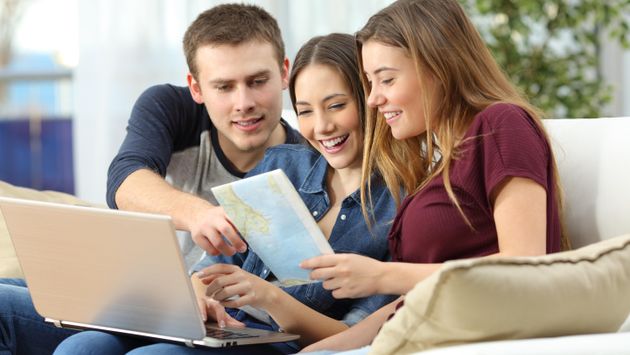 Three friends planning travel at home