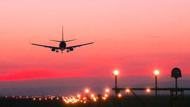 Plane lands at an airfield at the sunset