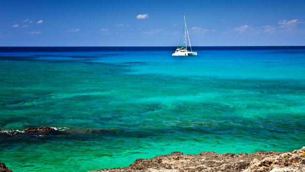 Large catamaran sailing in Grand Cayman, Cayman Islands (photo via fallbrook/iStock/Getty Images Plus)