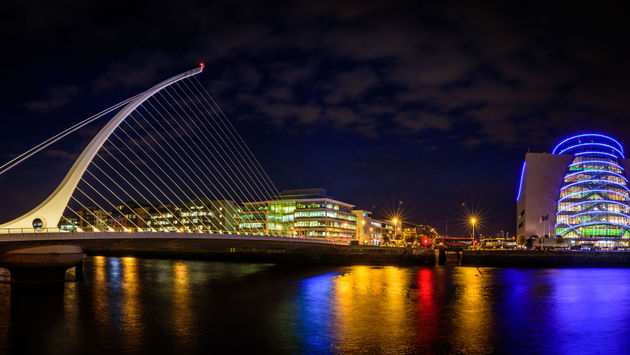 Panorama of Dublin by night. River with citylights reflections. Samuel Beckett Bridge. (photo via muzzyco / iStock / Getty Images Plus)